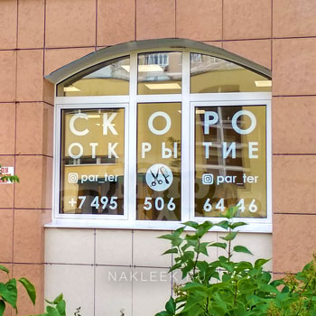 Рекламные надписи, вырезанные из белой плёнки на стекле