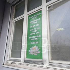 Фото перфорированной наклейки с рекламой на окне