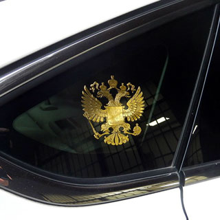 Золотой герб на заднем стекле авто